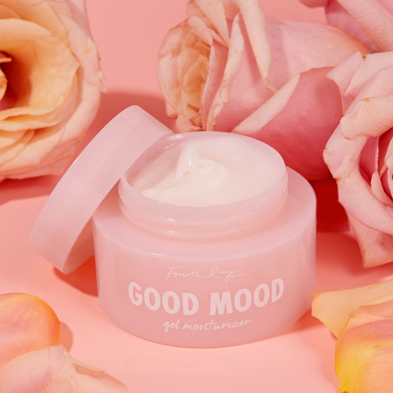 Good Mood gel moisturizer , with an open lid ; in front of pink roses
