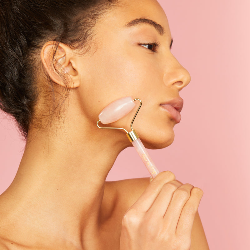 Model using rose quartz roller on her face